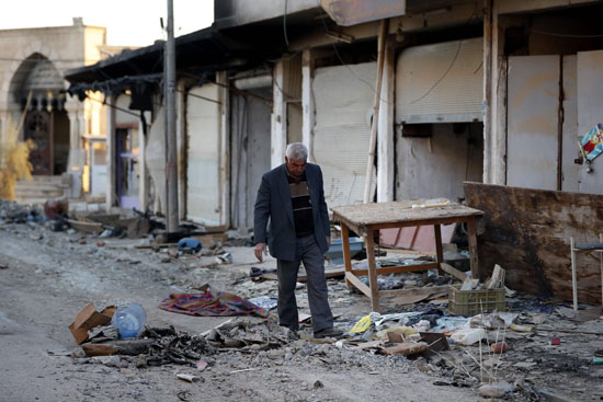  مواطن عراقي يمشى وسط الحطام بسبب الحرب فى الموصل 