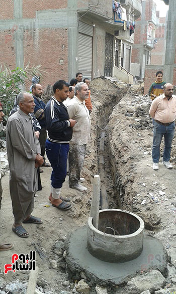 أحد المواطنين يحاول عمل قواعد خرسانية للبناء عليها وقيامه بالحفر بالقرب من المساكن الغارقة بمياه المجارى