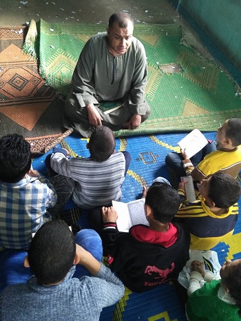 الشيخ محمد أثناء تعليم الأطفال التجويد