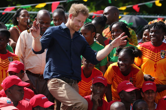 الأمير البريطاني هاري يداعب الأطفال خلال زيارة له فى إحدى المدارس