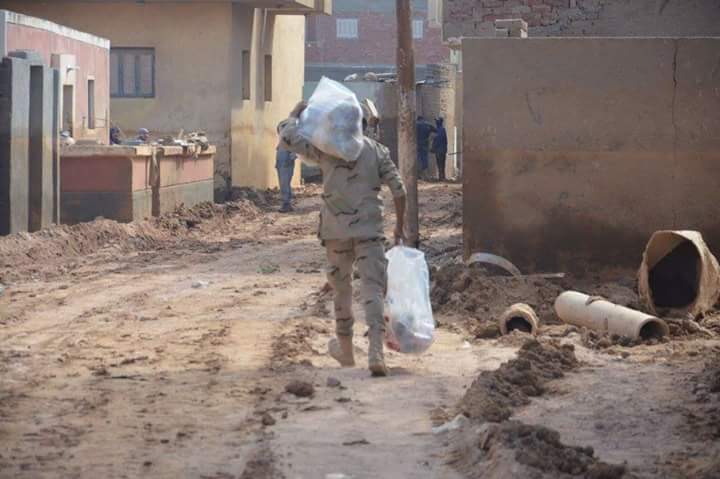 أحد رجال الجيش يحمل مساعدات لتقديمها للأسر المتضررة