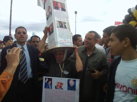 صابر أحمد صياد يحمل عمود فوق رأسه عليه زعماء وعلماء مصر