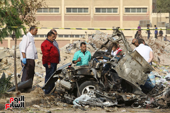  المواطنون يتفقدون السيارة بعد انفجارها