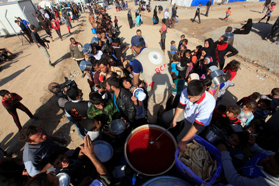 الفارون من جحيم حرب الموصل يتلقون الأطعمة فى مخيم "الخازر" بأربيل