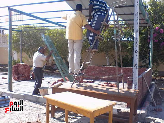 مدير مدرسة جمال عبد الناصر يعمل فى إنشاء مظلة للطلاب