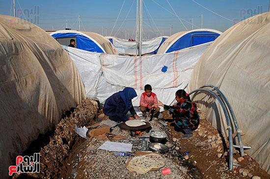 النساء المهجرات العراقيات الذين فروا من معقل داعش فى الموصل وهم يتناولون الخبر بمخيم خازر