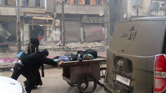 سوريون يحملون أطفالهم على عربة شرق حلب