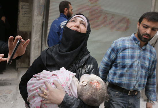 سيدة سورية تحمل طفلها المصاب فى شرق حلب