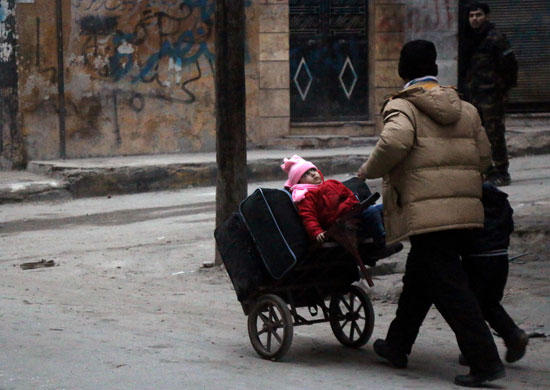 أسرة تحمل رضيعها على عربة شرق مدينة حلب