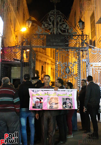 احد المتضامنون المسلمين يرفع لافتة للبابا و الرئيس السيسي أمام الكنيسة المرقسية