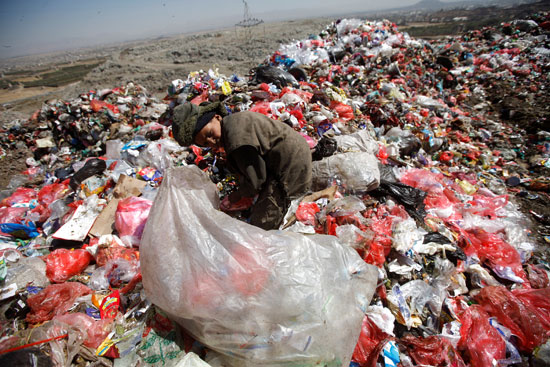 أطفال يجمعون القمامة وسط جبل القمامة 