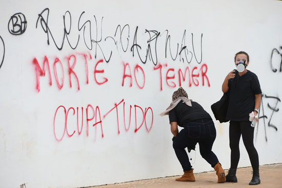 متظاهرون يكتبون على الحوائط