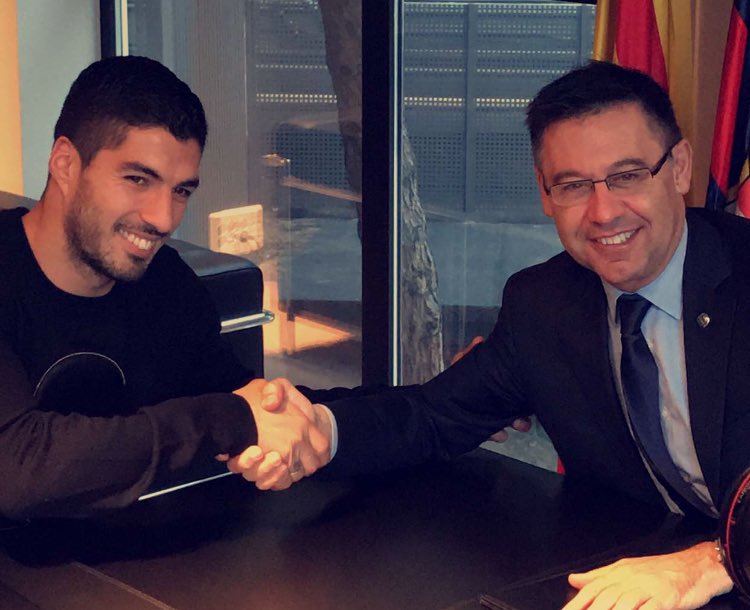 سواريز يصافح رئيس برشلونة بعد التوقيع على عقد التجديد