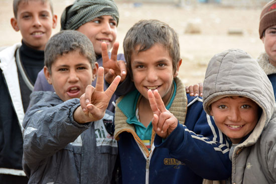  أطفال عراقيين يرفعون شعار علامة النصر فى ظل استمرار العمليات العسكرية فى الموصل