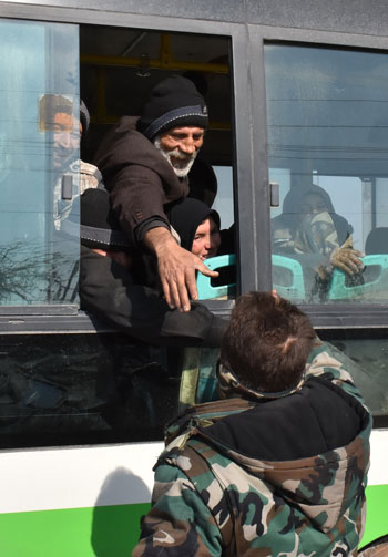 جندى يصافح مواطن سورى تم إجلاؤه من شرق حلب