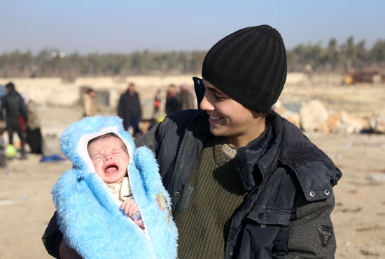 مواطن-سورى-يحمل-طفله