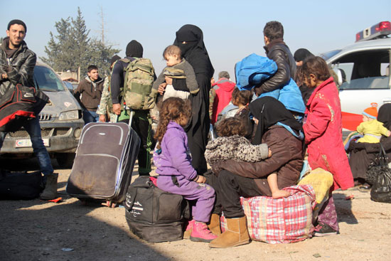 مواطن سورى يحمل طفله