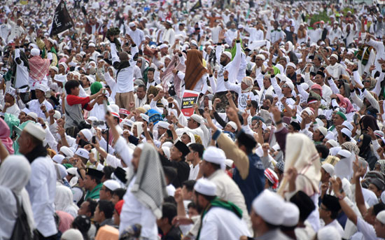 مواطن اندونيسى يقف وسط حشد من المتظاهرين 