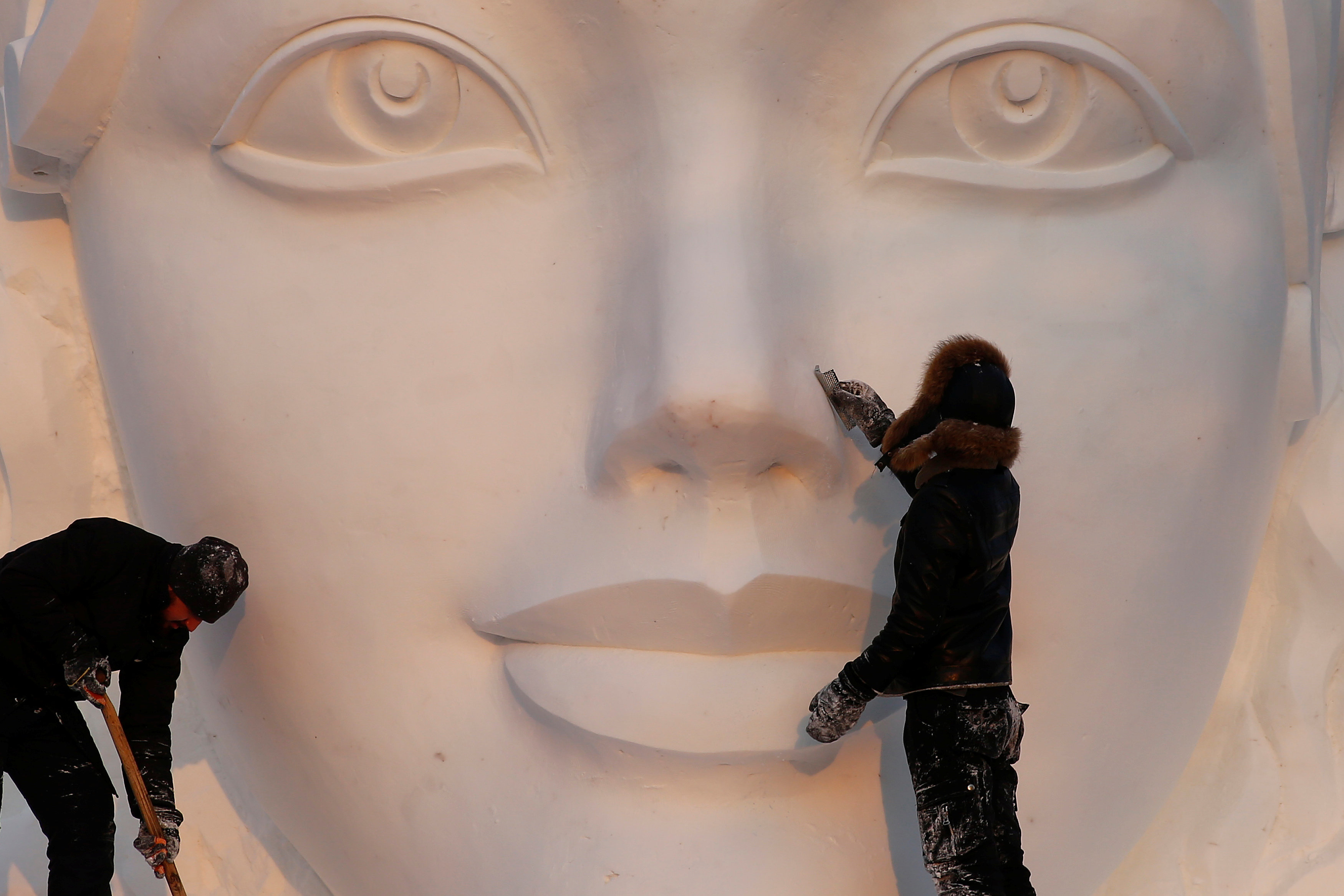 فنانون ينحتون تمثالا استعداد لمهرجان هاربين العالمي لنحت الثلج والجليد في الصين -رويترز