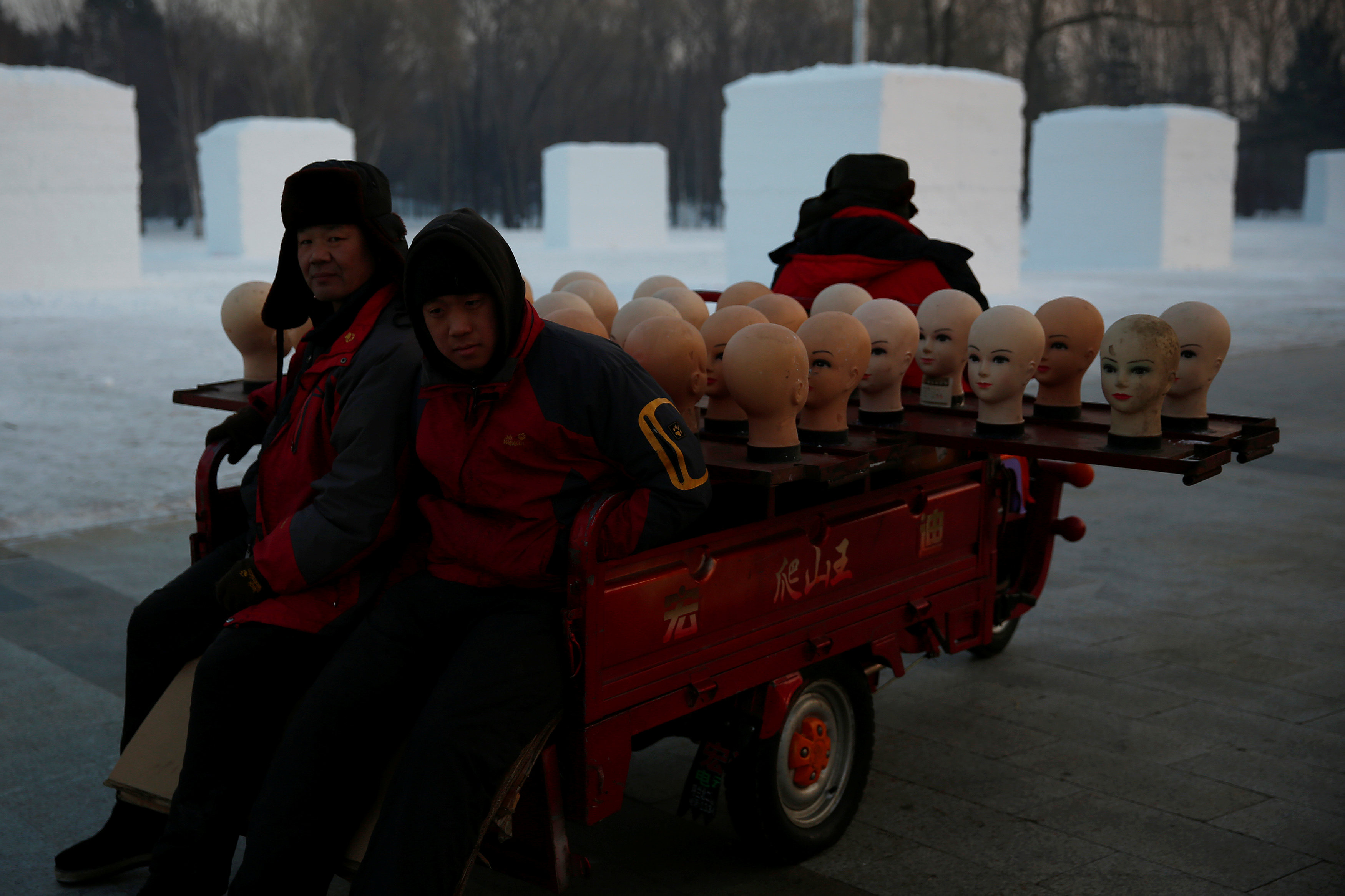 عمال يستعدون لبيع قبعات في مهرجان هاربين العالمي لنحت الثلج والجليد في الصين -رويترز