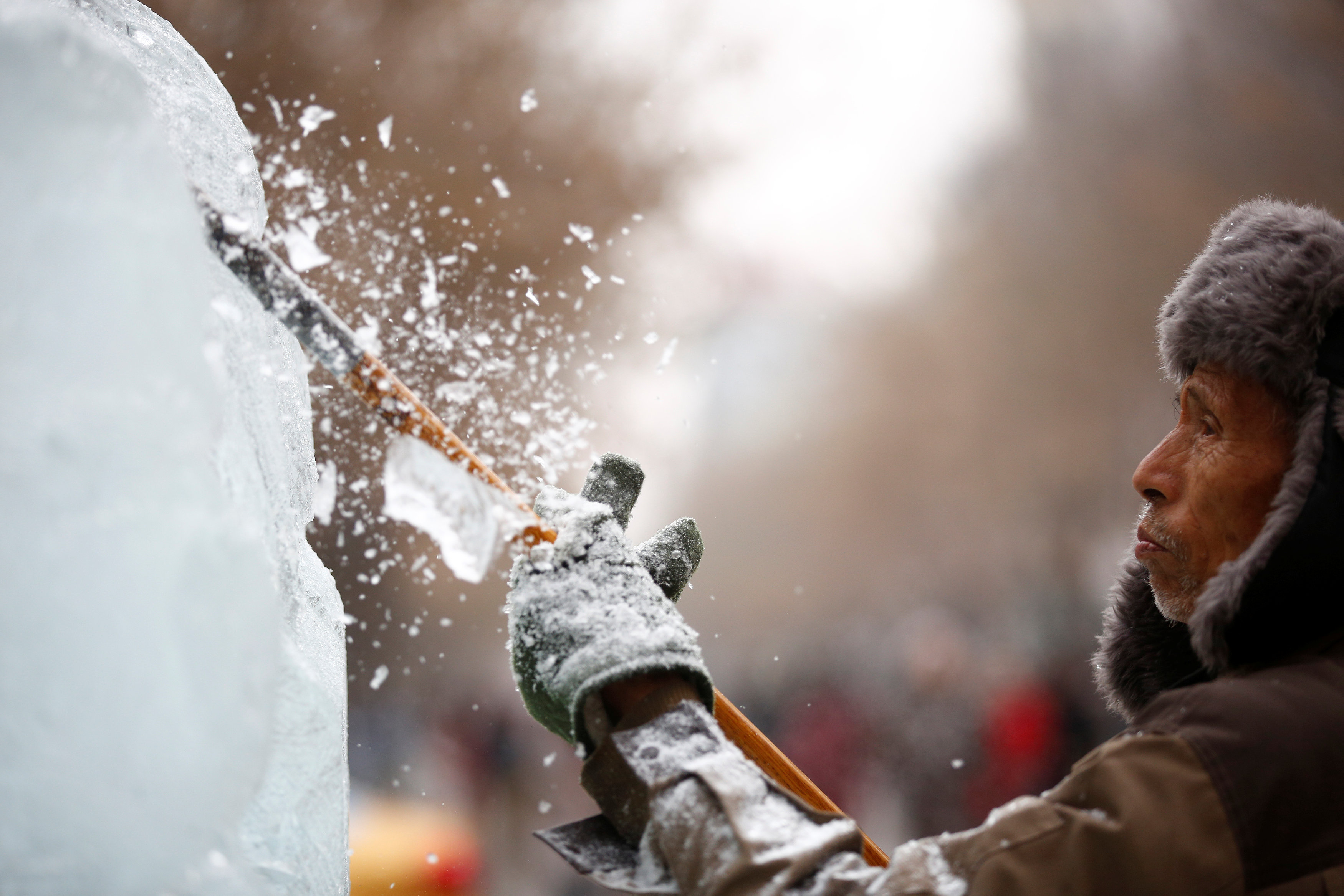 عامل ينحت ثتمثالا من الثلج فى مهرجان هاربين العالمي لنحت الثلج والجليد في الصين - رويترز