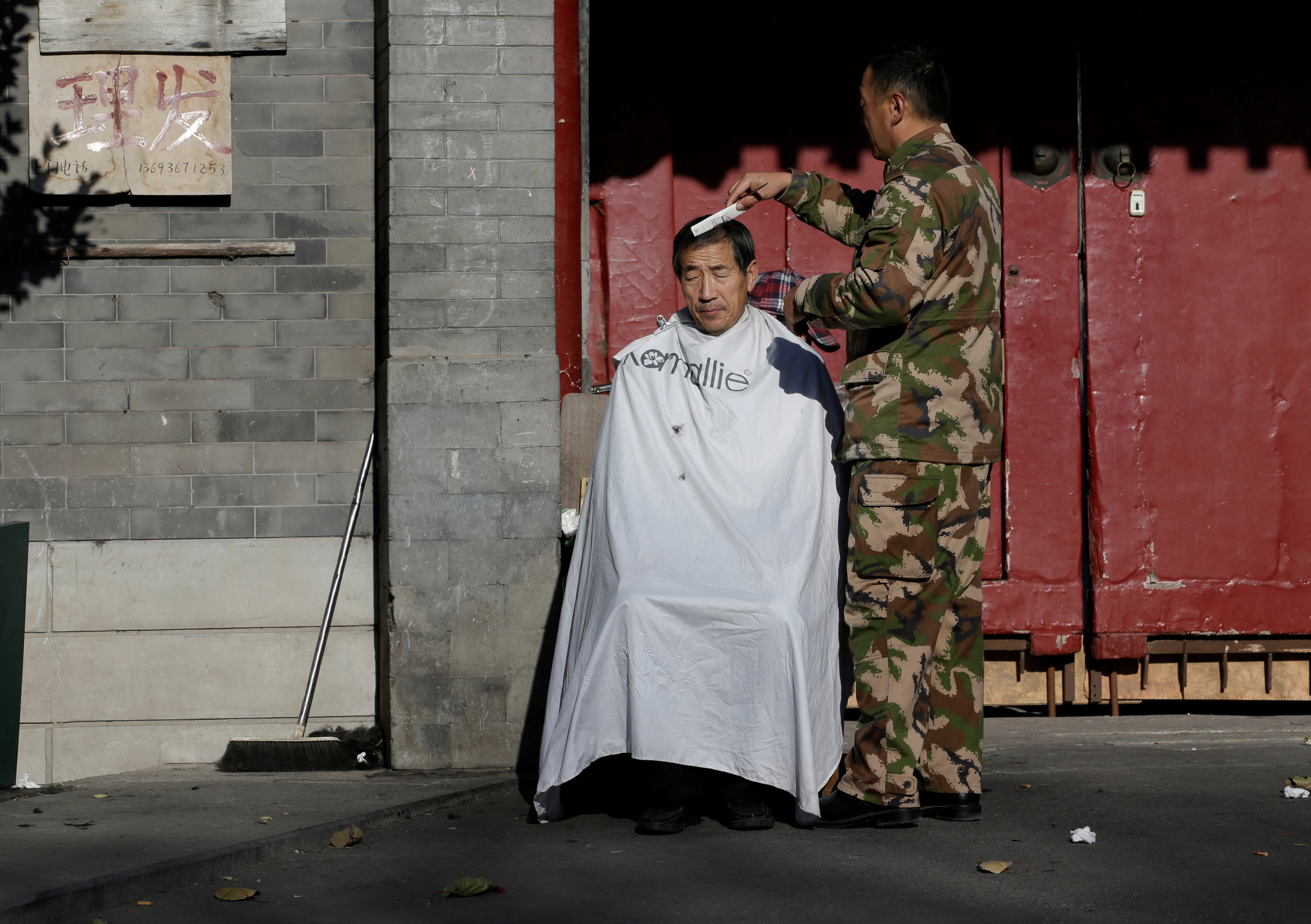 مواطن صينى  يحلق شعره وسط المارة
