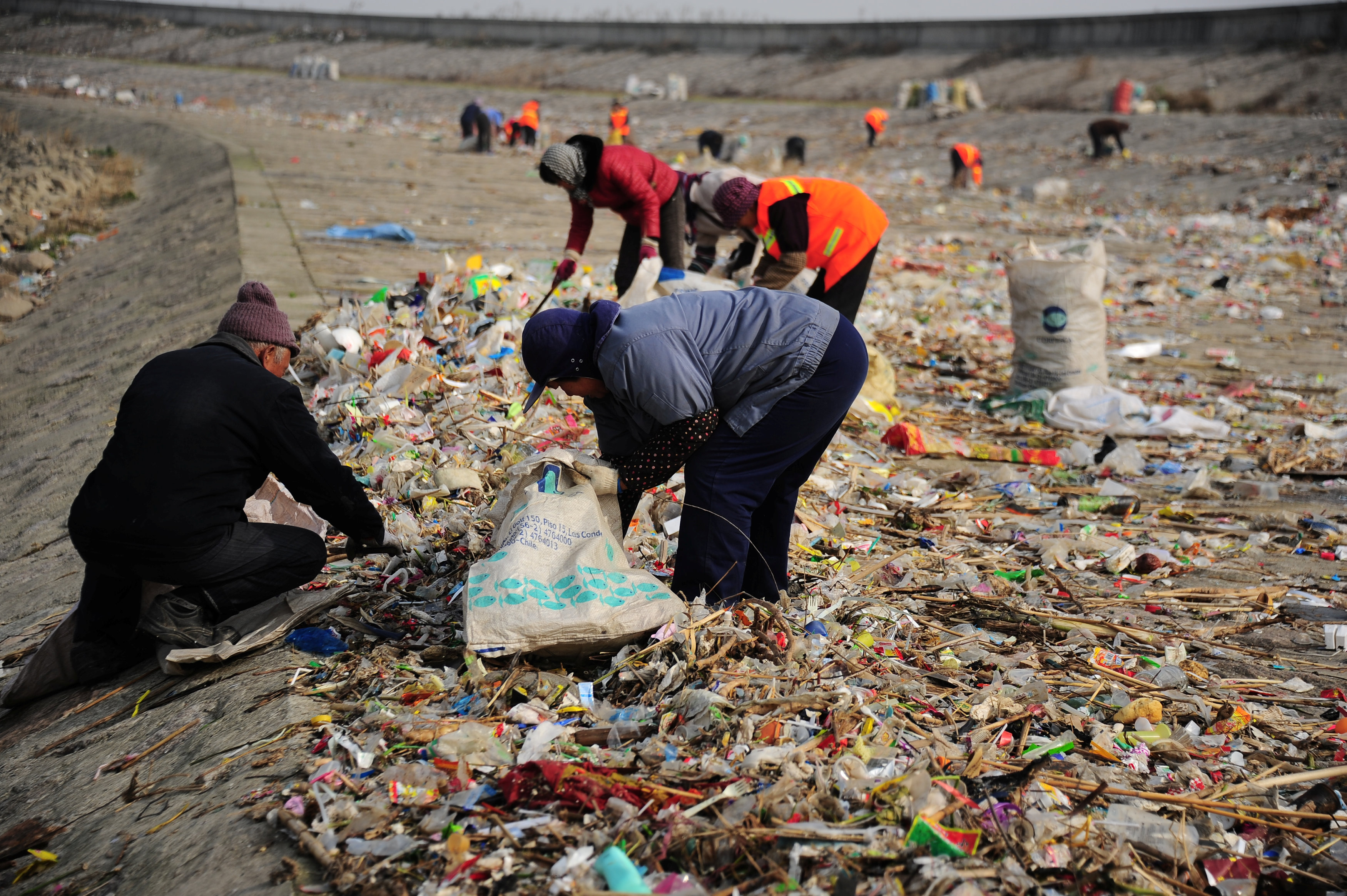 الصينيين يحاولون جمع المواد النافعة من القمامة على ضفاف نهر اليانجستى بالصين
