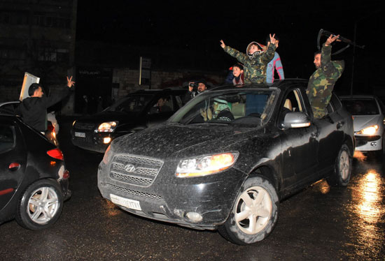 جنود يحملون السلاح يحتفلون بتحرير حلب