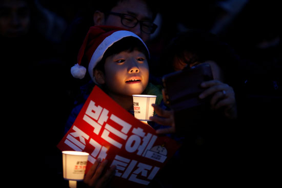 متظاهرون في كوريا الجنوبية يرتدون زى سانتا كلوز ويطالبون برحيل باك