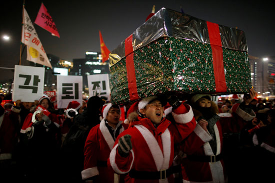 متظاهرون في كوريا الجنوبية يرتدون زى سانتا كلوز فى تظاهرة ضد رئيسة باك