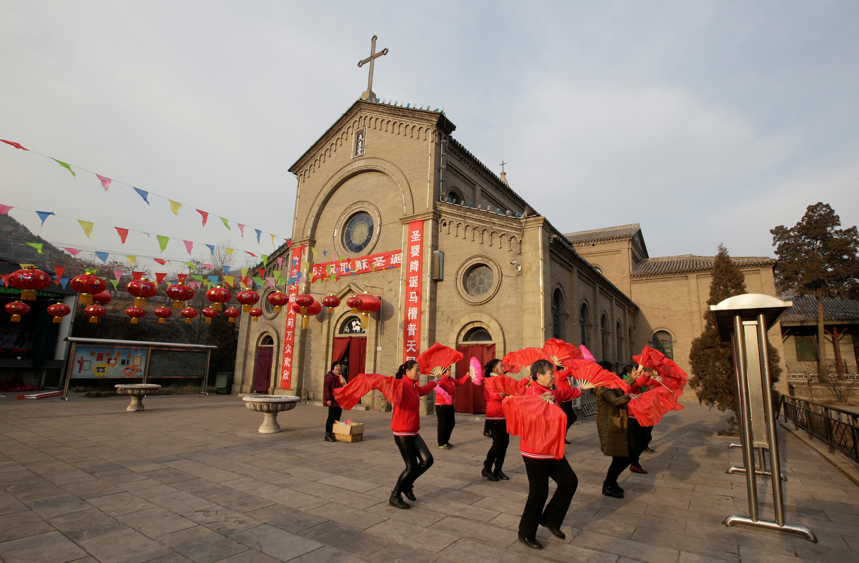 قرويون صينيون يرقصون خارج الكنيسة الكاثوليكية احتفالا بعيد الميلاد فى تاى يوان (1)
