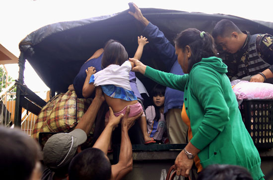  أطفال ونساء ومسنين على متن عربة نقل لاجلائهم قبل اقتراب إعصار "نوك-تن" – أ ف ب