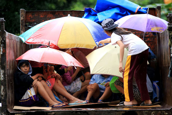 أطفال ونساء ومسنين على متن عربة نقل لاجلائهم قبل اقتراب إعصار "نوك-تن" – أ ف ب