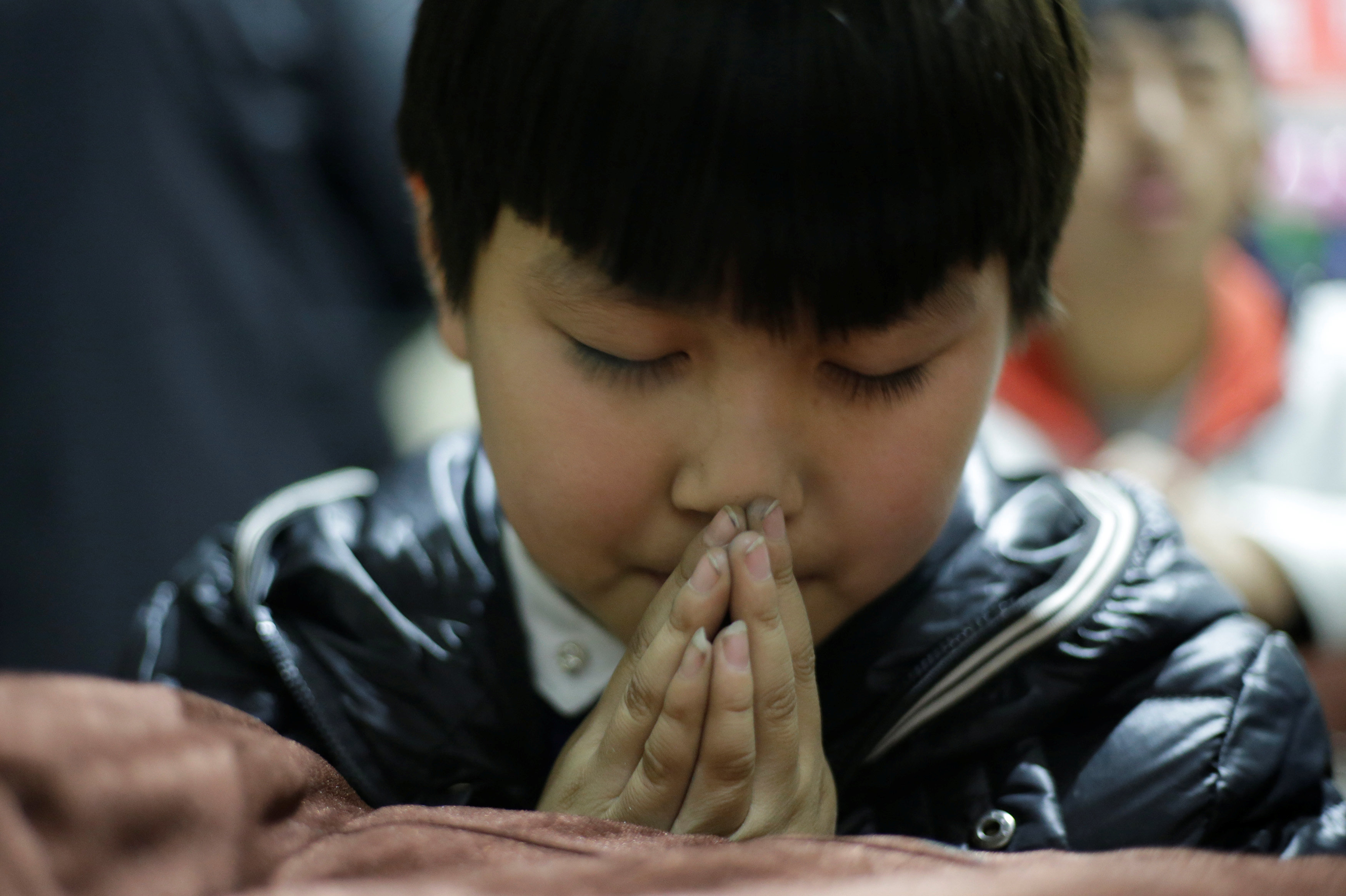 طفل صينيى خلال قداس عيد الميلاد بالكنيسة الكاثويكية فى تاى يوان