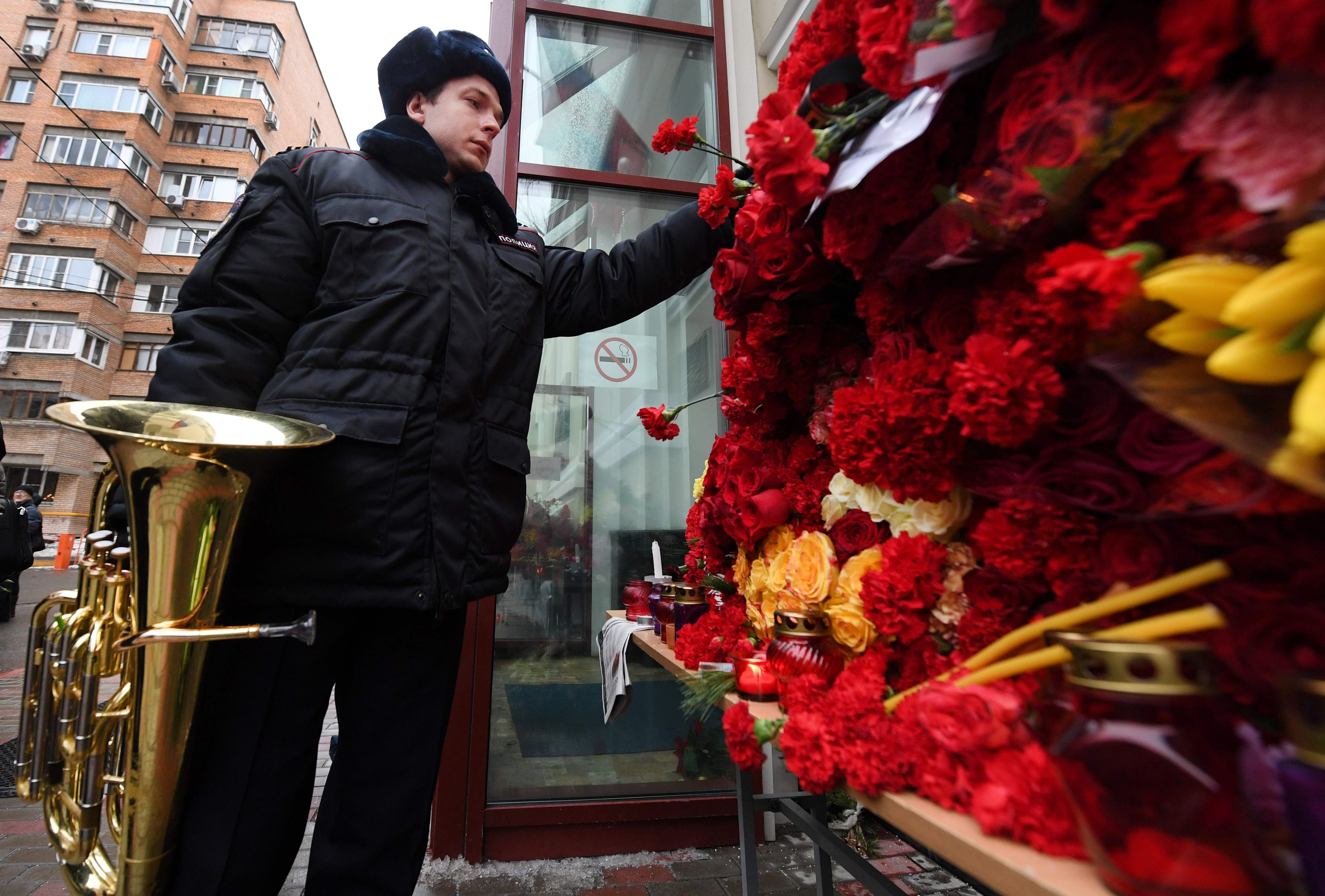 موسيقى روسى يضع الزهور على باب مسرح فريقة اليككسندروف ضحايا الطائرة المنكوبة
