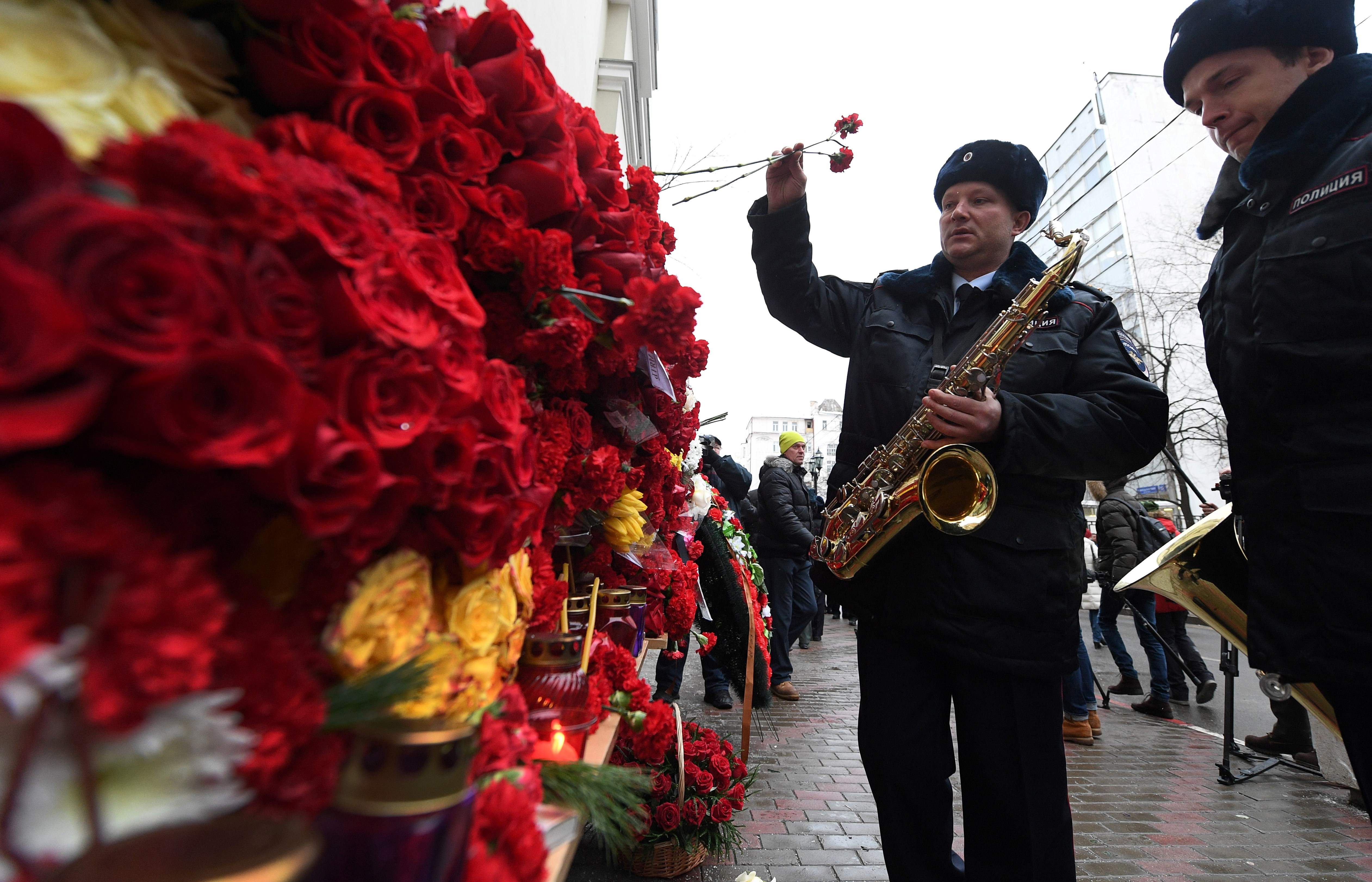 موسيقون روس يضعون الزهور على مبنى فرقة اليككسندروف ضحايا الطائرة المنكوبة