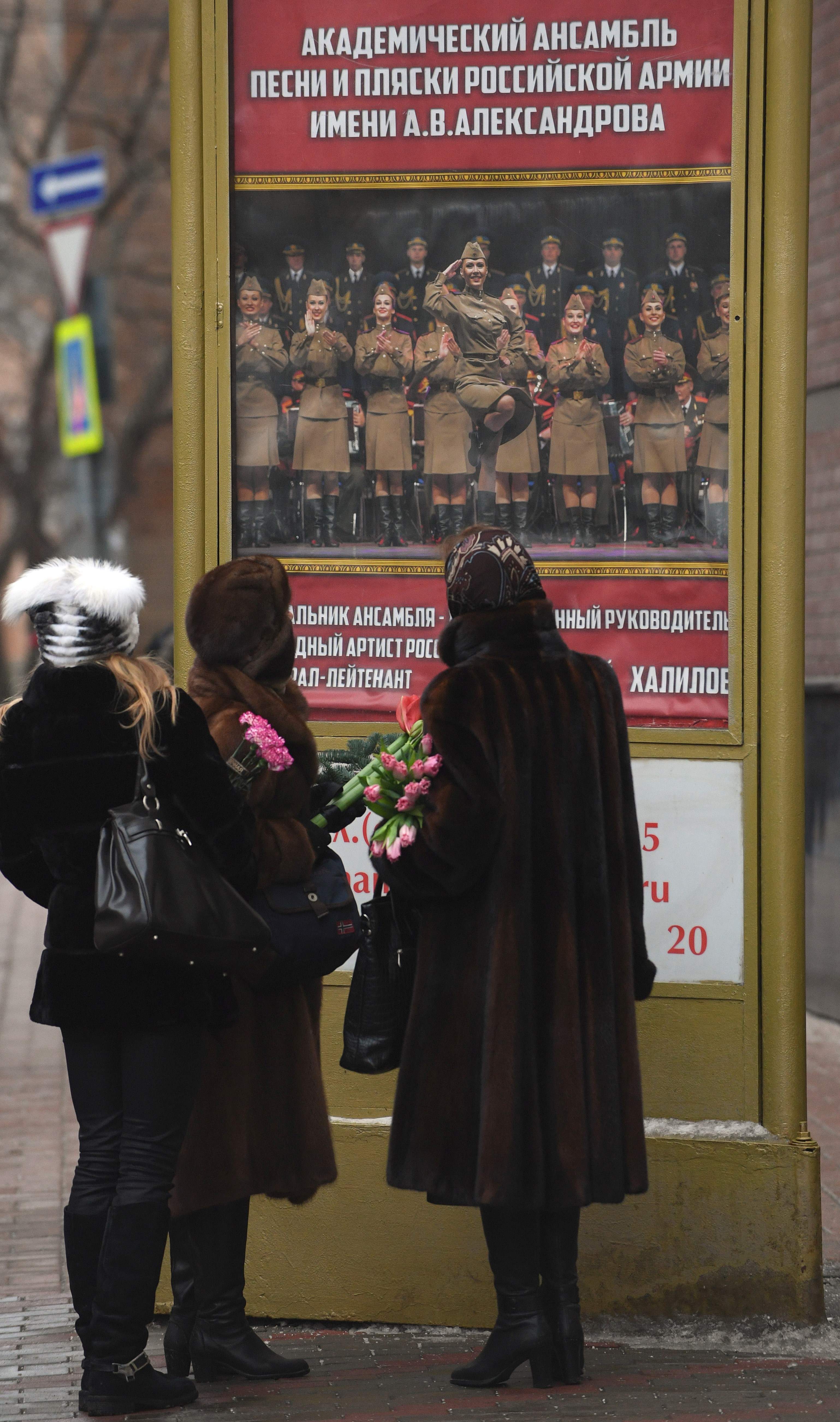 روسيات يضعن الزهور على باب مبنى مسرح الفرقة الموسيقية التابعة للجيش الروسى