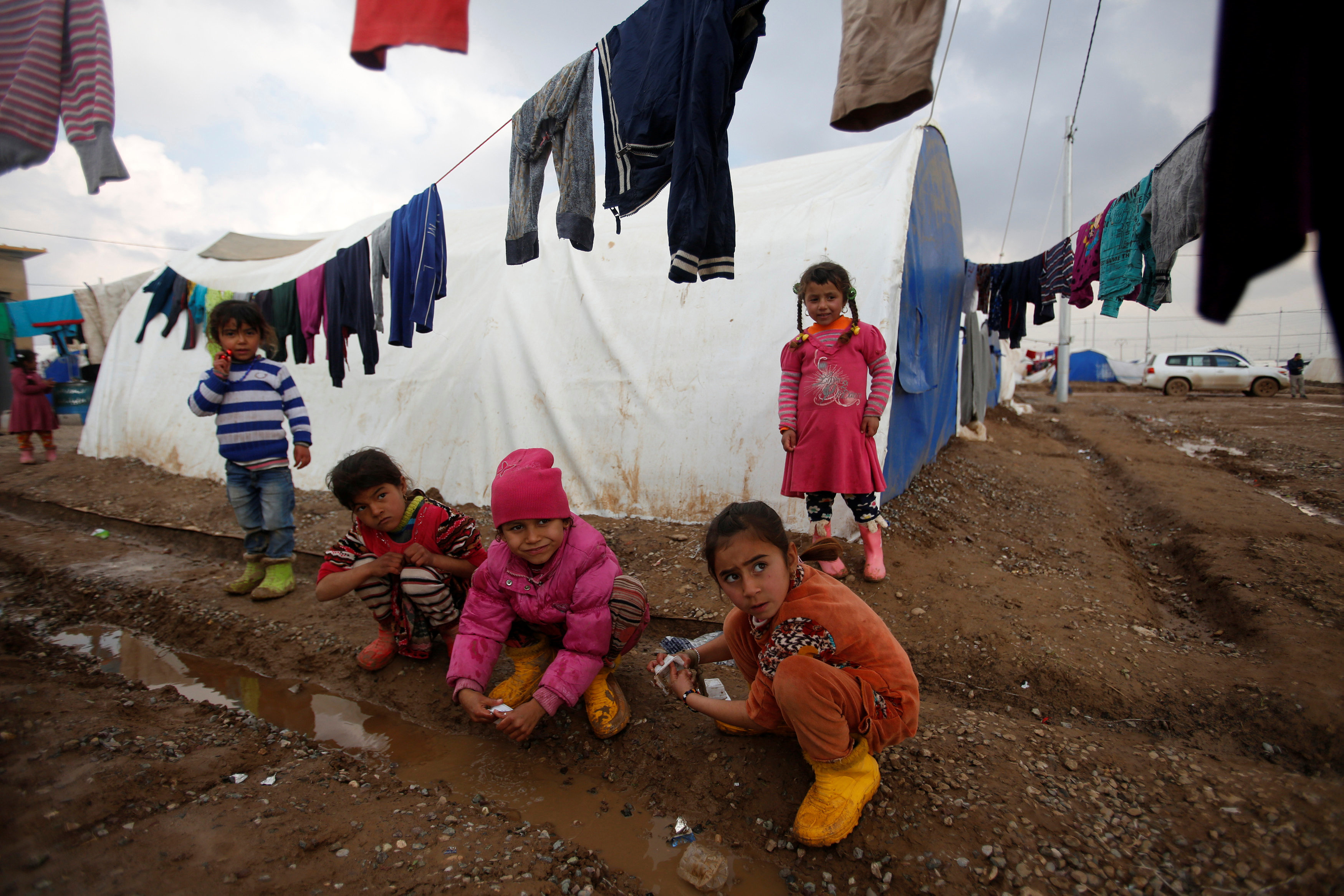 أطفال يلهون بمياه الأمطار فى المخيم 