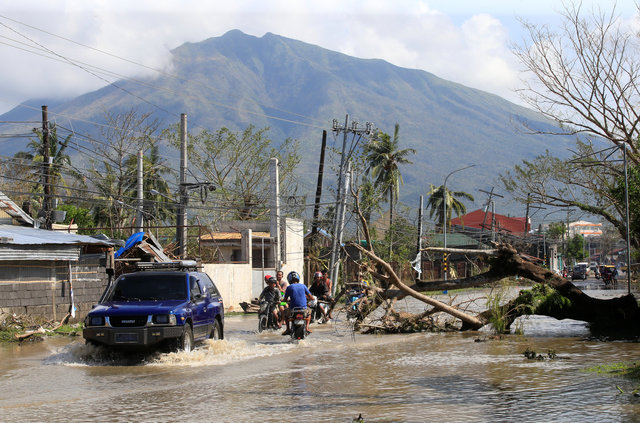 سيارات الدفع تسير في شوارع مليئة بالمياه بعد اعصار الفلبين