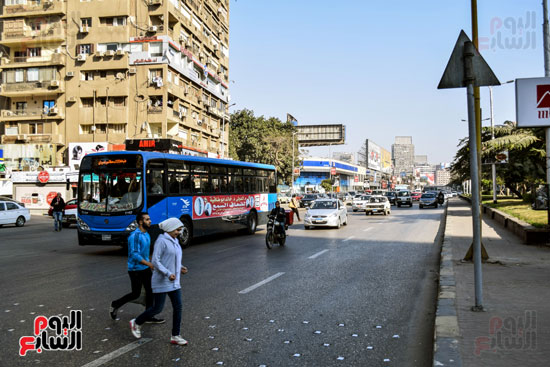 شباب يعبرون الطريق وسط السيولة المرورية