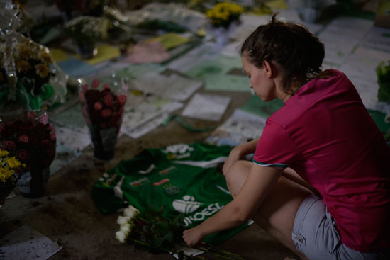 فتاة تضع ورود خلال تأبين ضحايا تحطم طائرة فريق برازيلى