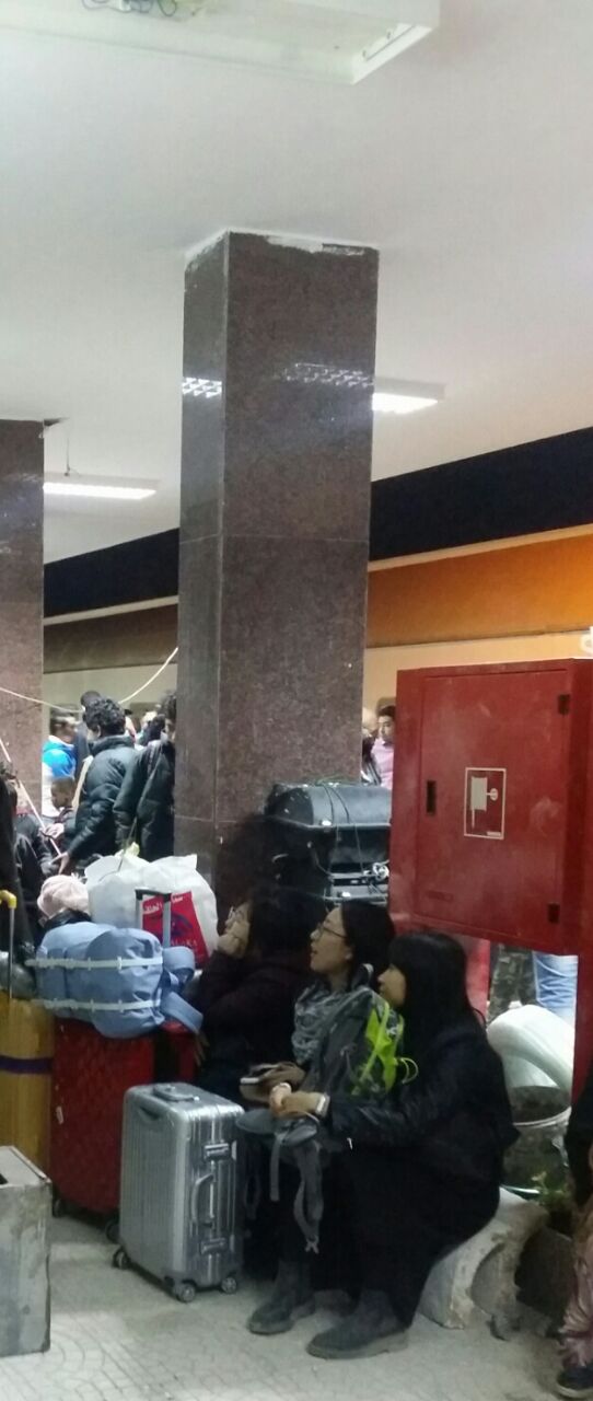 سائحون أجانب يجلسون على حقائب السفر