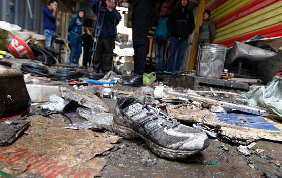 	عراقيون مجتمعون فى موقع تفجير قنبلةه فى أحد الأسواق وسط بغداد 
