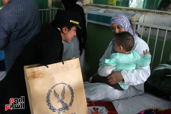  ضابطة تقدم هدية لطفل مريض بمستشفى أبو الريش