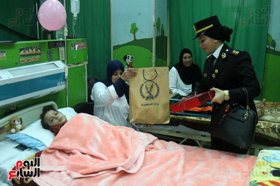  ضابطة تهدى طفل مريض بمستشفى أبو الريش هدية