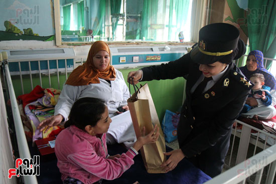  ضابطة تقدم هدية لطفل مريض بمستشفى أبو الريش