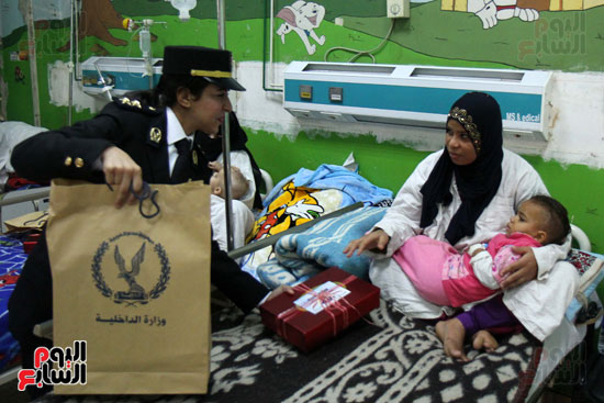 ضابطة تقدم هدية لطفل مريض بمستشفى أبو الريش