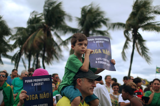 طفل يرفع لافتة ضد الفساد فى البرازيل 