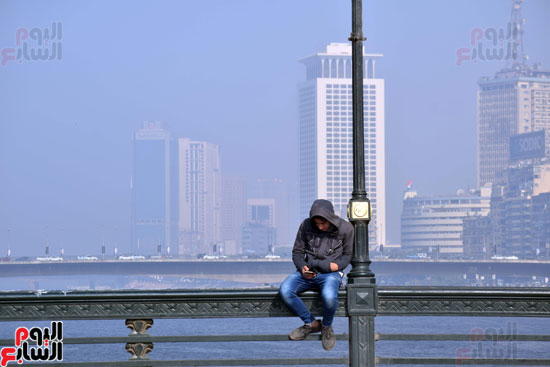 شاب يستمتع بالجو على كوبرى قصر النيل