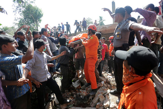 عمال الانقاذ يبحثون عن ضحايا تحت أنقاض أحد المنازل  